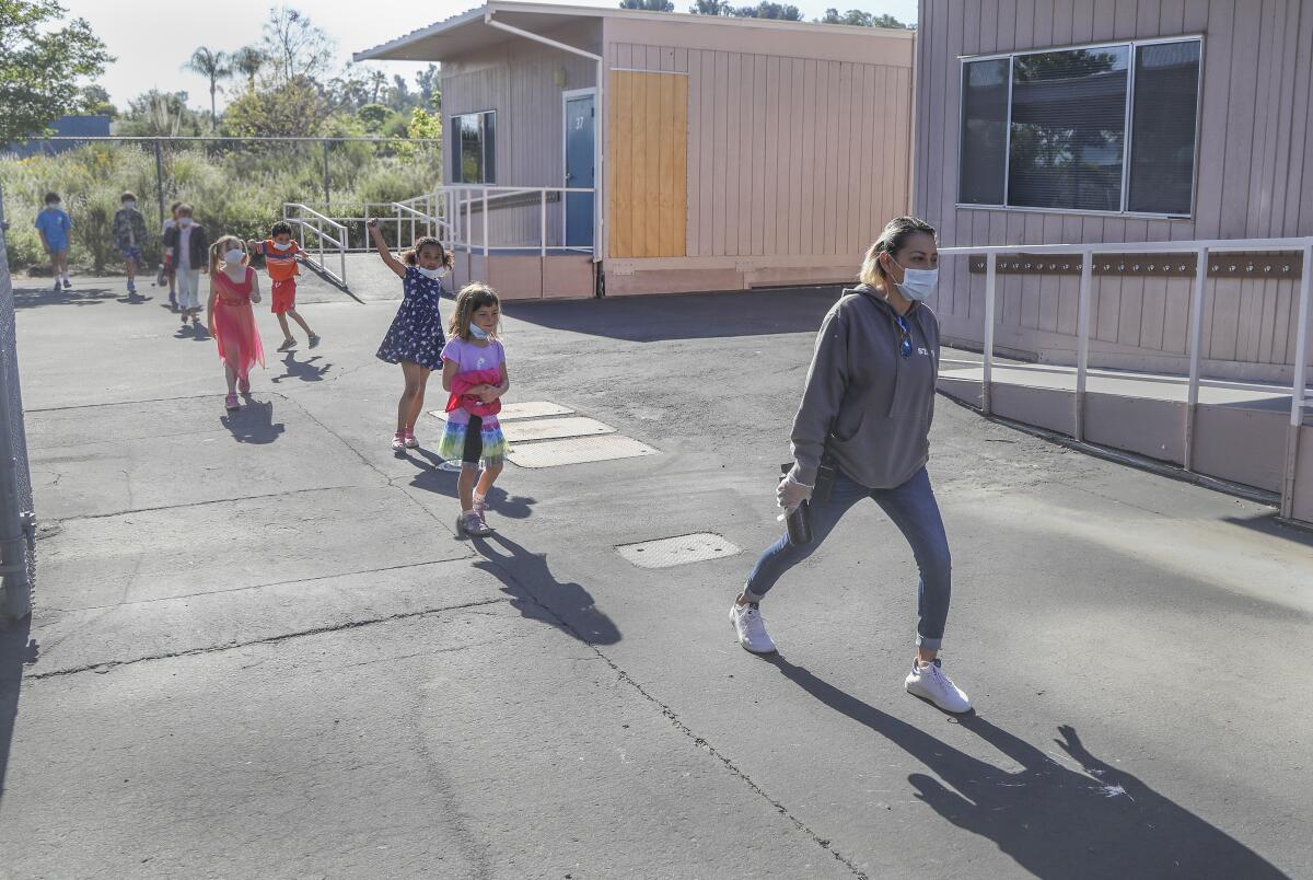 Maria Limas (right) leads children back to the classroom at Chase Avenue Elementary School May 5 in El Cajon.