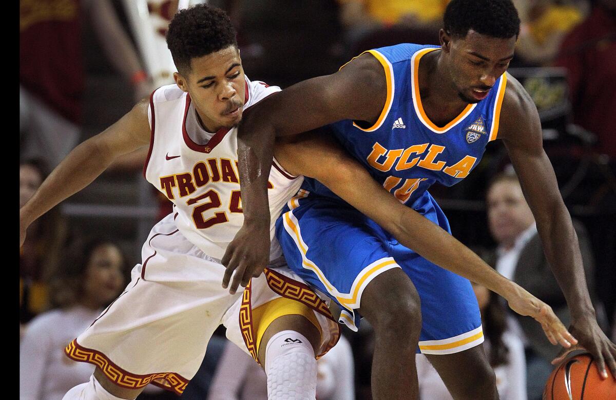 UCLA's Isaac Hamilton dribbles the ball while USC defender Malik Marquetti tries to steal the ball away during the Bruins' 83-66 win over the Trojans on Jan. 14.