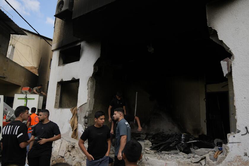 Palestinians stand outside a heavily damaged mosque following an Israeli military operation in the West Bank refugee camp of Al-Faraa, Thursday, Aug. 29, 2024. (AP Photo/Nasser Nasser)