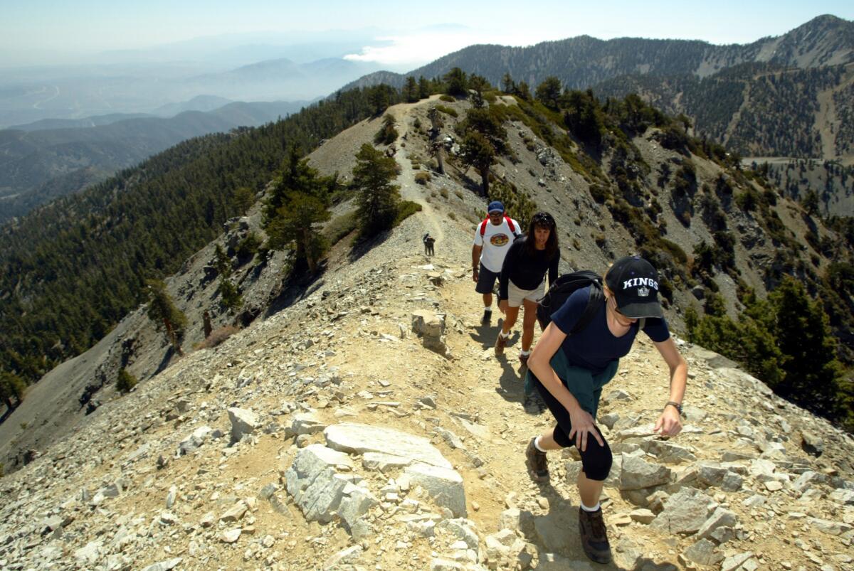 Hikers make it to the top of Mt. Baldy in the San Gabriel Mountains. A federal judge has ruled that visitors to Southern California's four national forests do not need to buy an Adventure Pass if they are only hiking and do not use forest facilities.