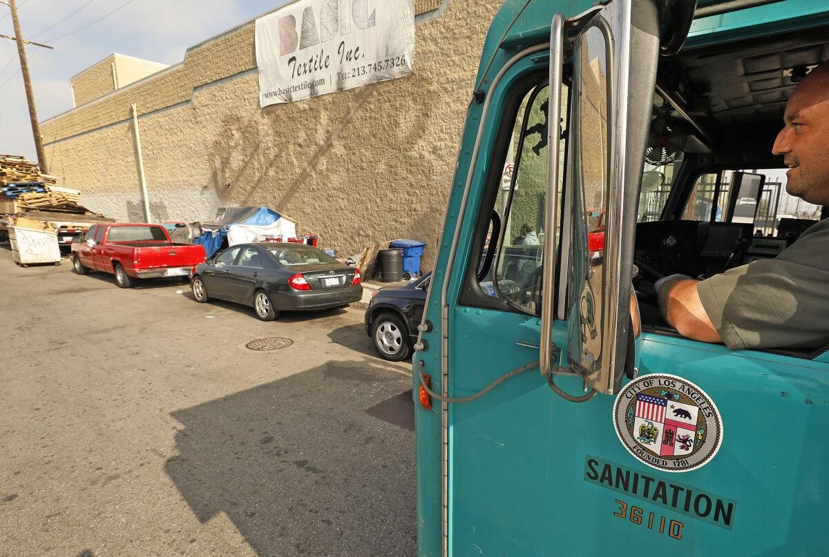 City of Los Angeles Bureau of Sanitation refuse collection truck operator Jake Nademlynsky, eyes a homeless camp at 41st Place and Alameda St. (Al Seib / Los Angeles Times)