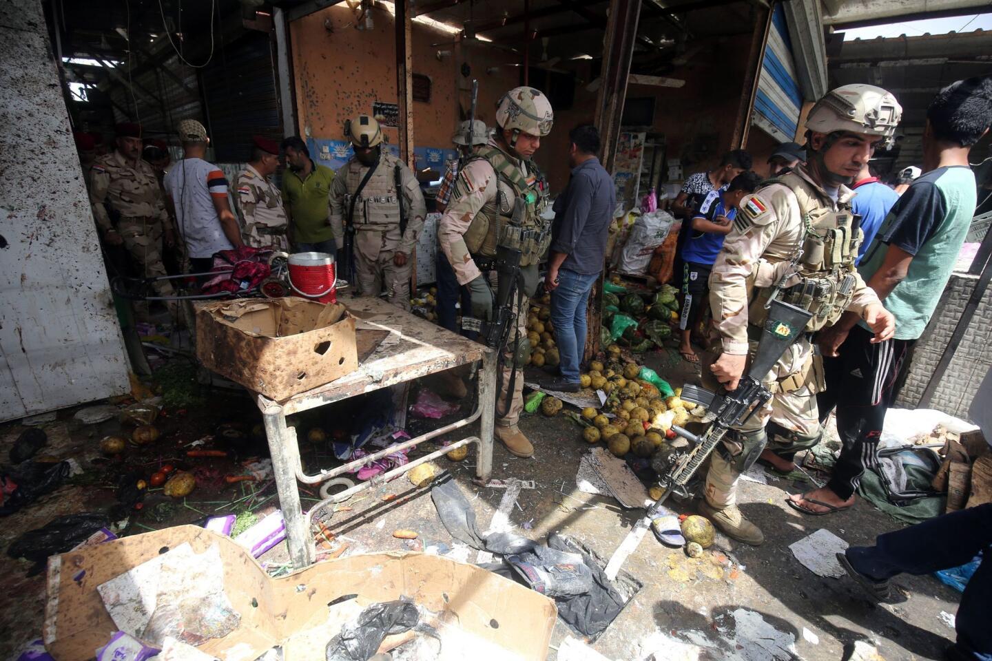 Iraqi security forces gather at the site of a suicide bombing in the Shaab area in northern Baghdad on May 17, 2016.