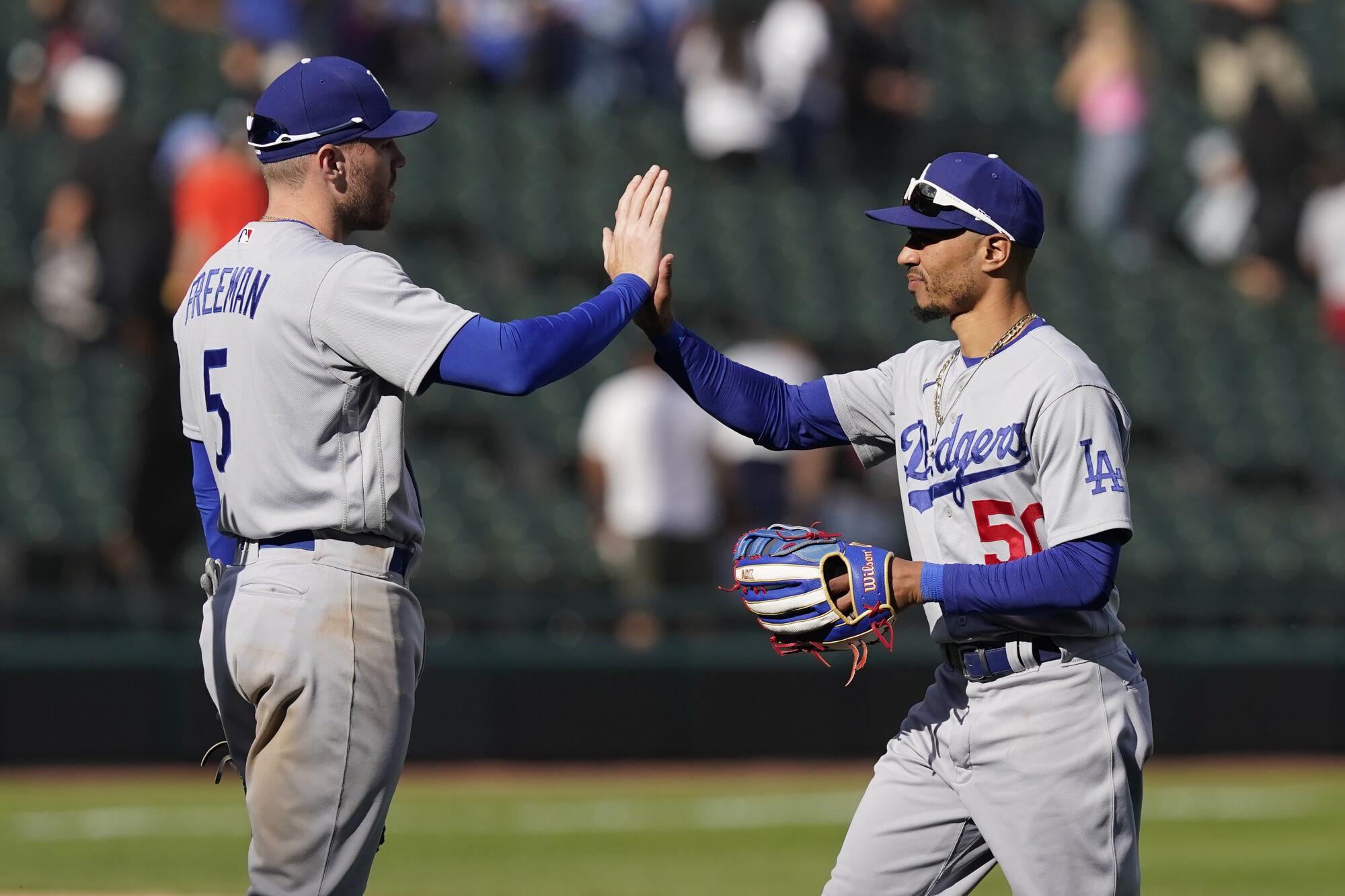 Freddie Freeman and Mookie Betts high-five to celebrate a Dodgers win.