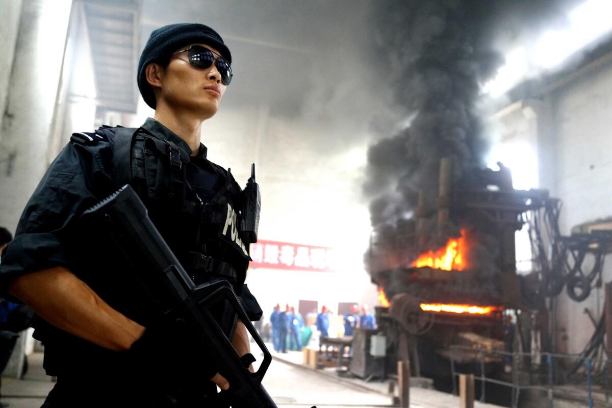 A policeman stands guard as authorities destroy drugs at a factory in Guiyang, China, in June 2013. More than 1,400 pounds of drugs including heroin and methamphetamine, along with more than 1,600 pounds of opium poppies, were destroyed to mark International Day Against Drug Abuse and Illicit Trafficking in 2013.