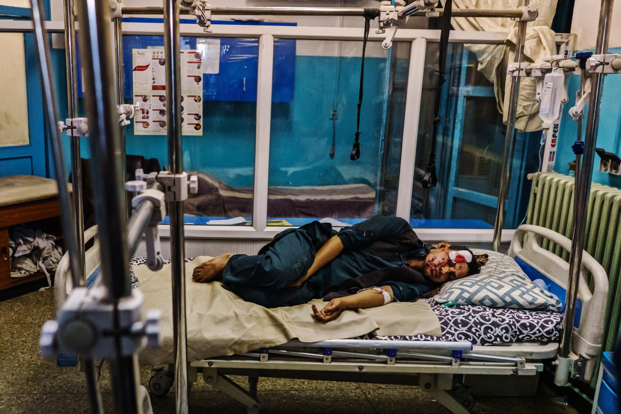 A wounded patient lies in the recovery unit at Wazir Akbar Khan Hospital