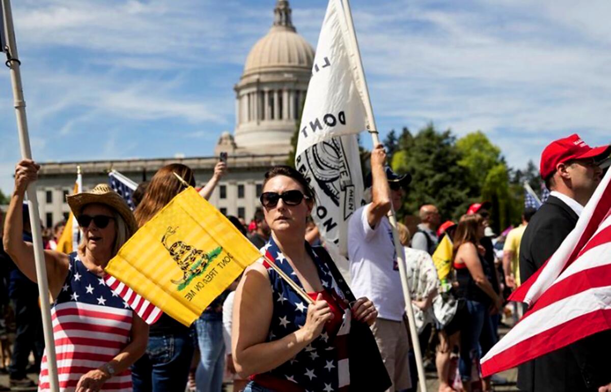 Tammy Snider, of Parkland, Wash., was one of an estimated 1,500 protesters at a rally in Olympia on Saturday against Washington state’s stay-at-home order in response to the COVID-19 pandemic. Some far-right groups have allied themselves with the movement to advance their agendas.