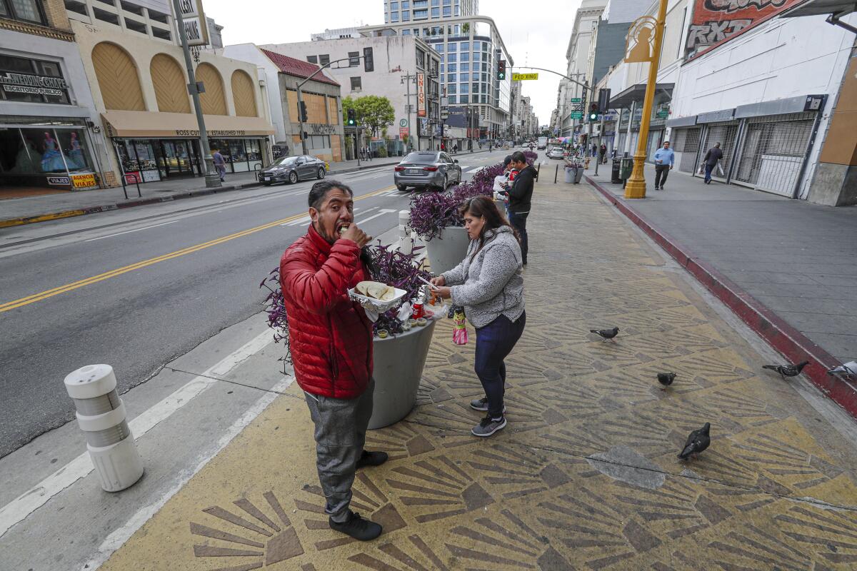 Quintanar Reyes, left, and his wife, Olga Martinez, eat their takeout lunch from Grand Central Market.