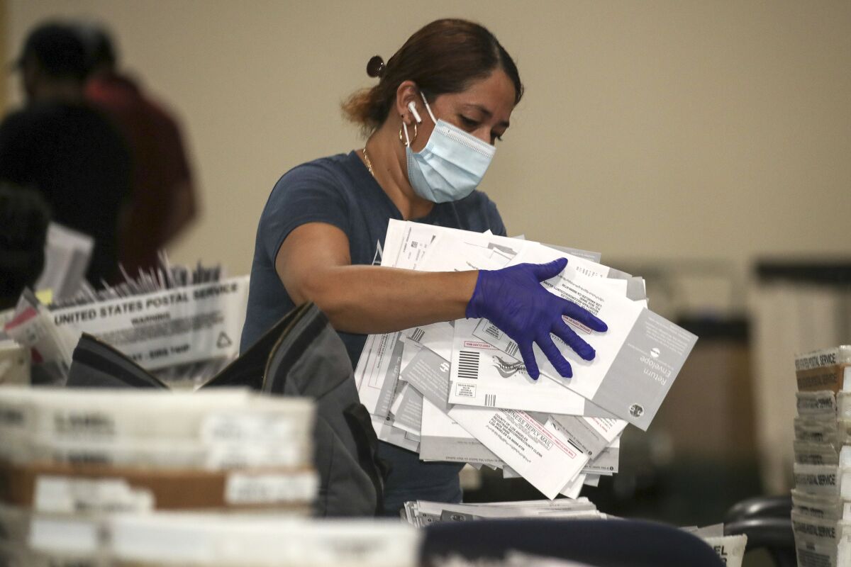Election worker Yolanda Lavayen carries recall ballots at the L.A. County registrar's satellite office in Pomona.