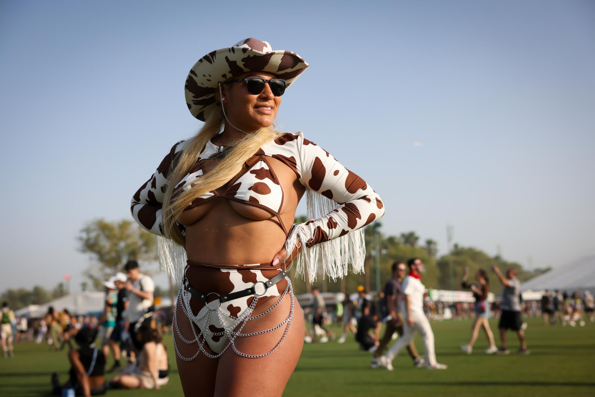 33 岁的丘拉维斯塔 (Chula Vista) 布伦达·拉米雷斯 (Brenda Ramirez) 在科切拉 (Coachella) 音乐节上身着奶牛印花套装，在沙漠阳光下闪闪发光。