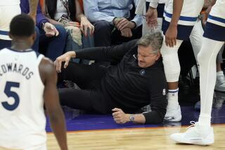 El entrenador de los Timberwolves de Minnesota Chris Finch se sujeta de la rodilla tras chocar con el base de los Timberwolves Mike Conley durante el cuarto partido contra los Suns de Phoenix por la primera ronda de los playoffs, el domingo 28 de abril de 2024. (AP Foto/Ross D. Franklin)