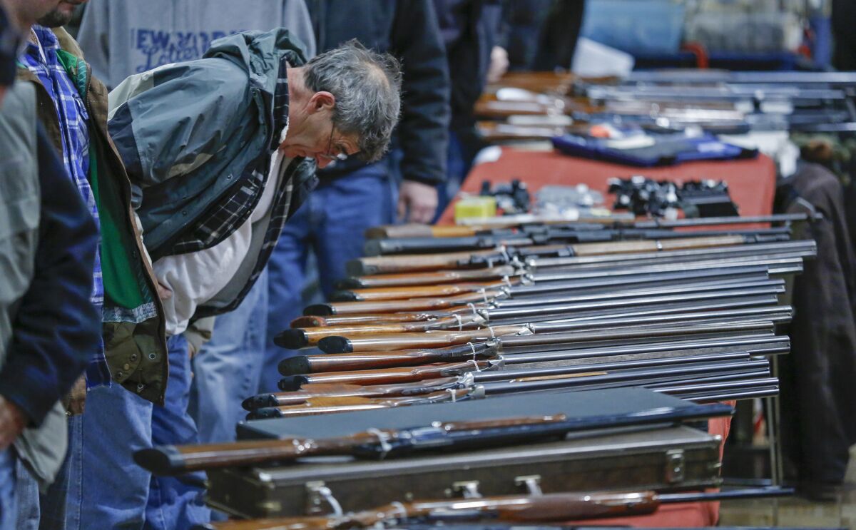 A customer looks over shotguns on display at the New York State Arms Collectors Assn. Gun Show in Albany.
