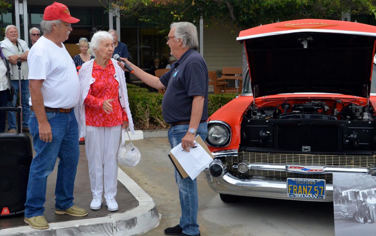 Kevin Spangler, his former teacher Marilyn Conrath and host Mike Zimmerman in front of Spangler's 1957 Chevy Nomad.