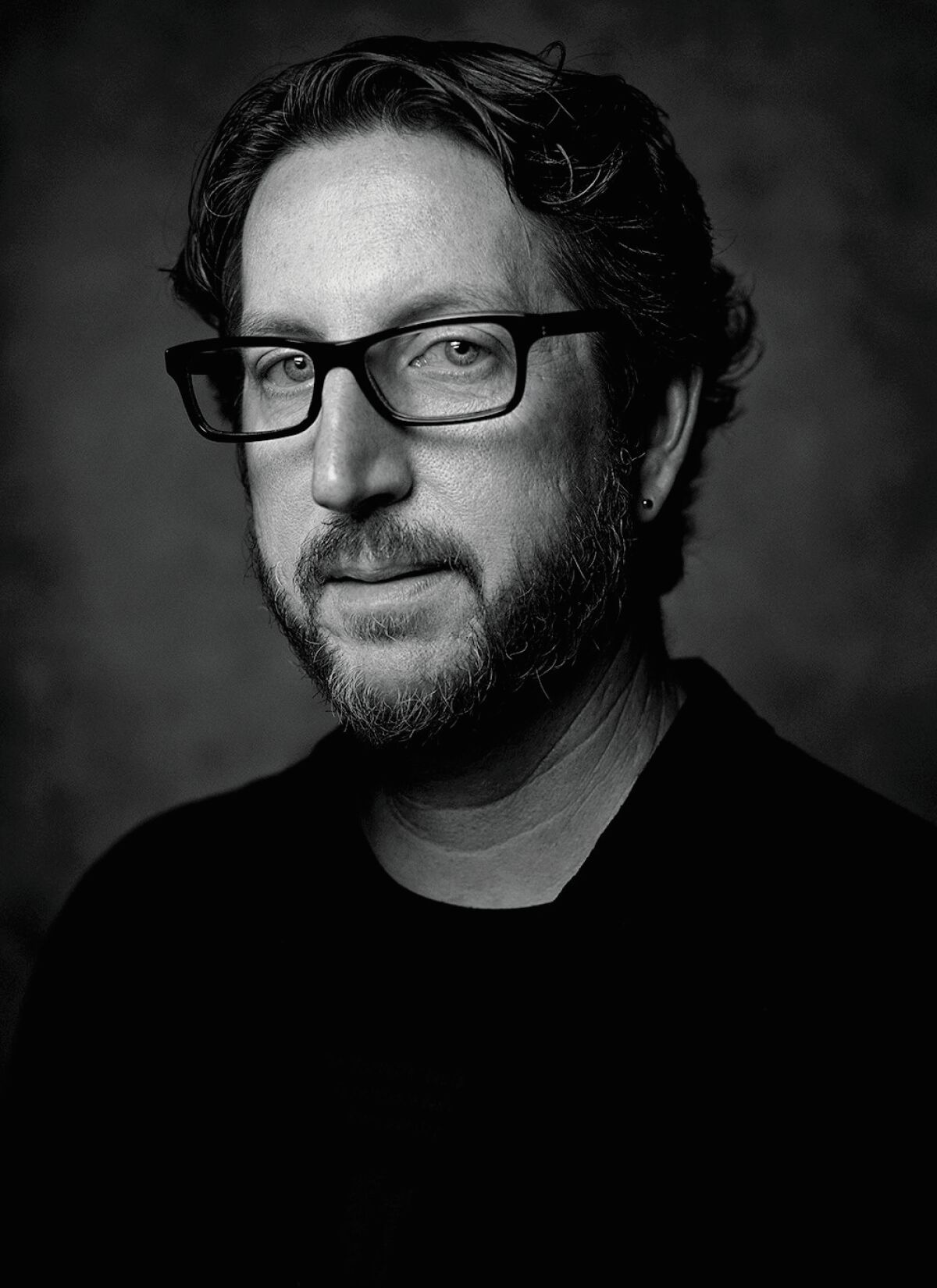 A black-and-white portrait of a man with glasses