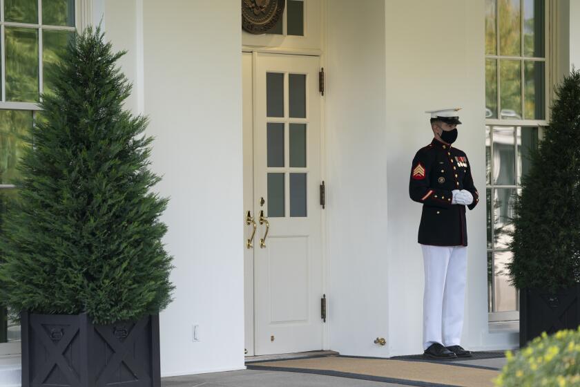 A Marine is posted outside the West Wing of the White House, signifying the President is in the Oval Office, Friday, Oct. 9, 2020, in Washington. (AP Photo/Evan Vucci)