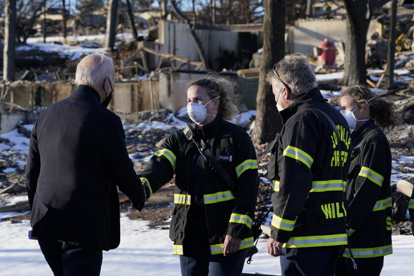 President Joe Biden greets first responders as he tours a neighborhood in Louisville, Colo., Friday, Jan. 7, 2022, that was impacted by the recent wildfire. (AP Photo/Susan Walsh)