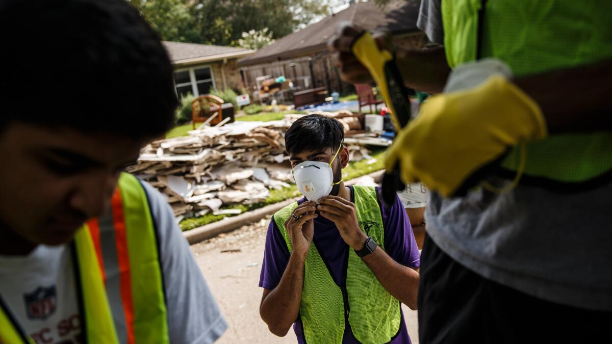 Sultan Munawar and other volunteers from the Ahmadiyya Muslim Youth Assn. don protective gear to help Houston residents clear out their homes.