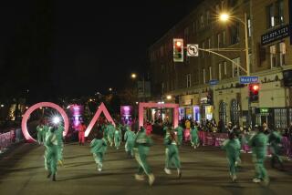 Fans run through large "Squid Game" icons outside the premiere of the second season of the Netflix series.
