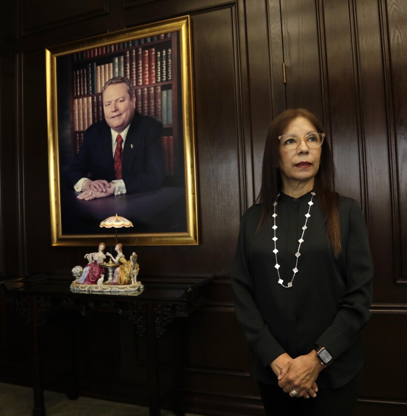 Liz Flynt stands next to a portrait of her late husband, Larry Flynt. 