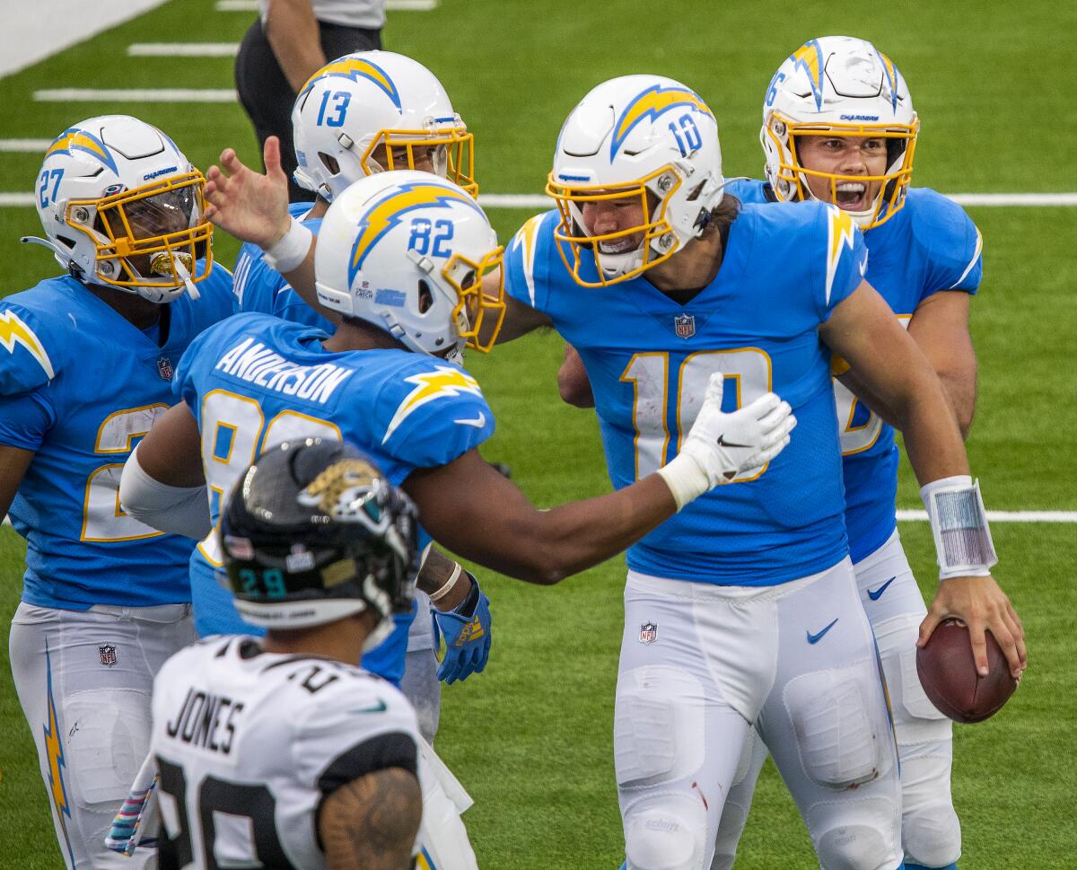 Chargers quarterback Justin Herbert is congratulated by teammates after his five-yard run for a touchdown. 