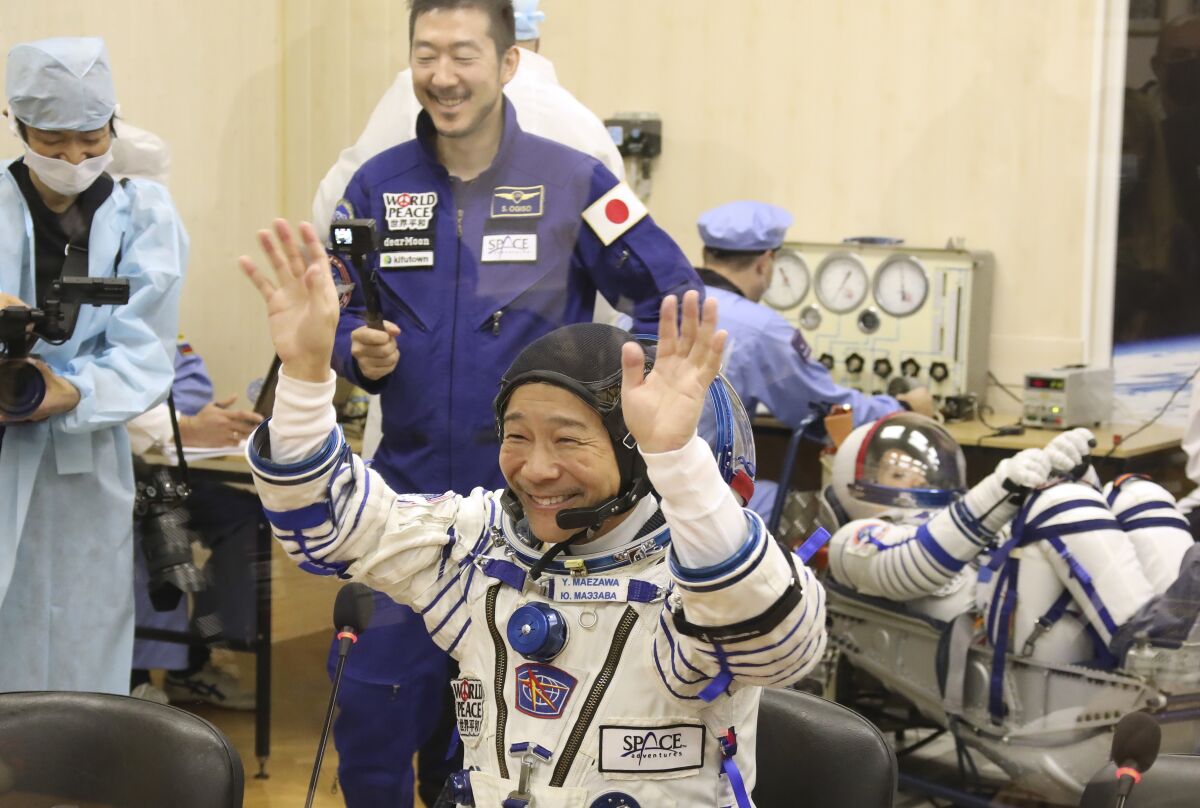 In this photo released by the Roscosmos Space Agency, spaceflight participant Yusaku Maezawa of Japan, member of the main crew of the new Soyuz mission to the International Space Station (ISS) gestures prior the launch at the Russian leased Baikonur cosmodrome, Kazakhstan, Wednesday, Dec. 8, 2021. (Pavel Kassin, Roscosmos Space Agency via AP)