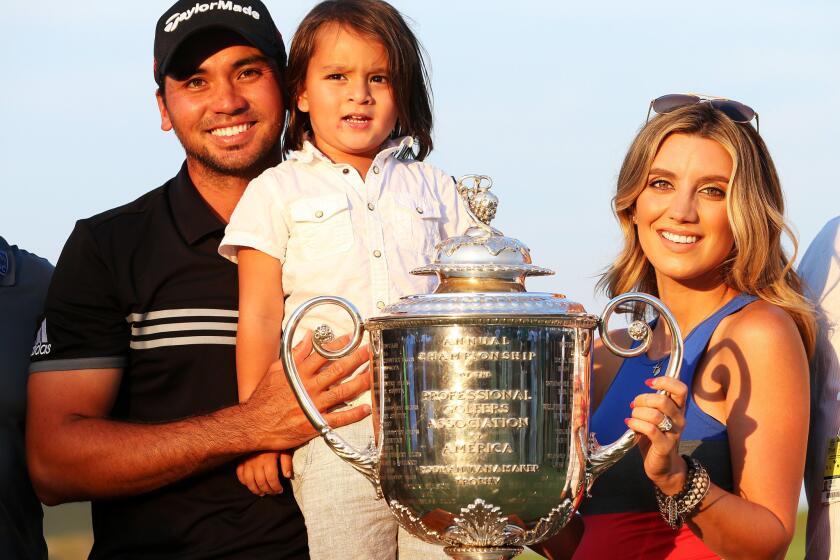Australian Jason Day poses with son Dash and wife Ellie after winning the Wanamaker Trophy at the PGA Championship on Sunday in Sheboygan, Wis.