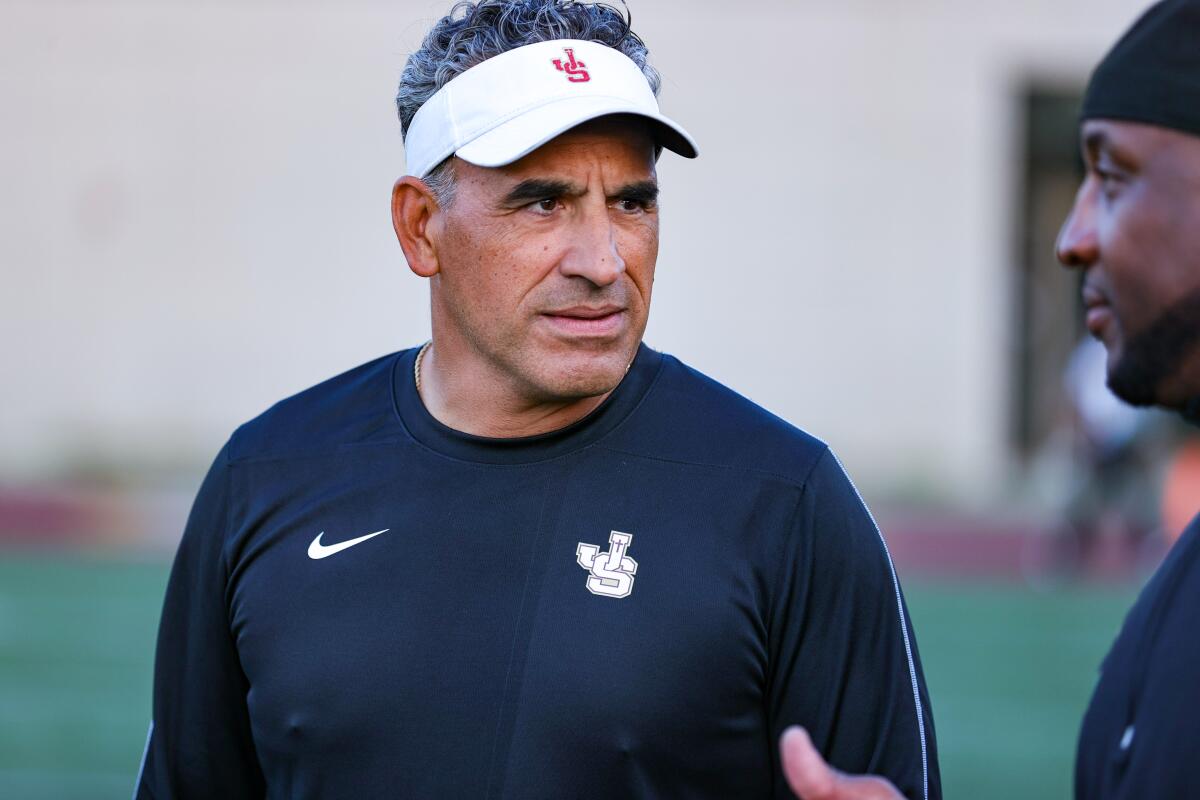 JSerra football coach Victor Santa Cruz talks to an assistant coach.