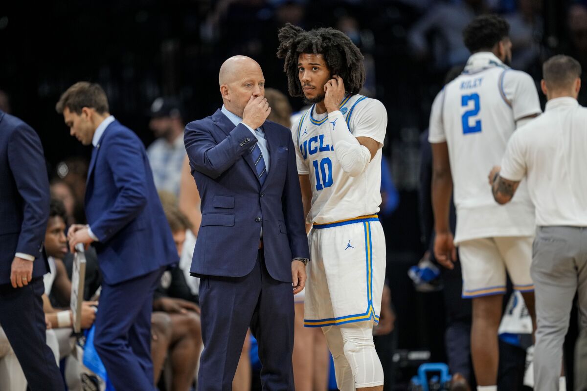 UCLA coach Mick Cronin talks with guard Tyger Campbell during a game.
