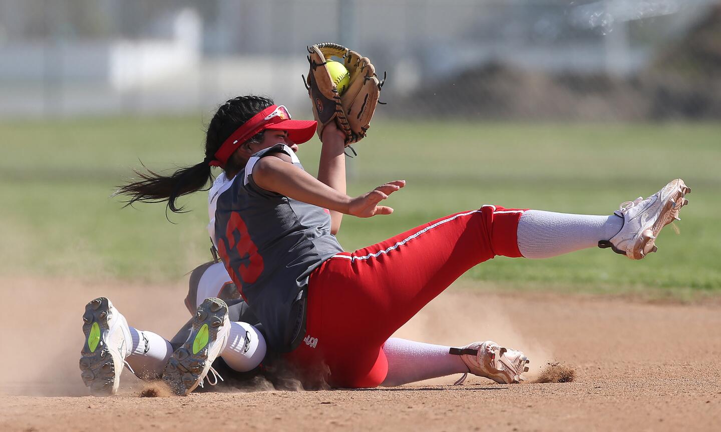 Los Amigos High baserunner Kayla Onofre tries to sneak under the tag of Loara's Alyssa Salas, who shows the ball for the out in a Garden Grove League game at Los Amigos on Tuesday.