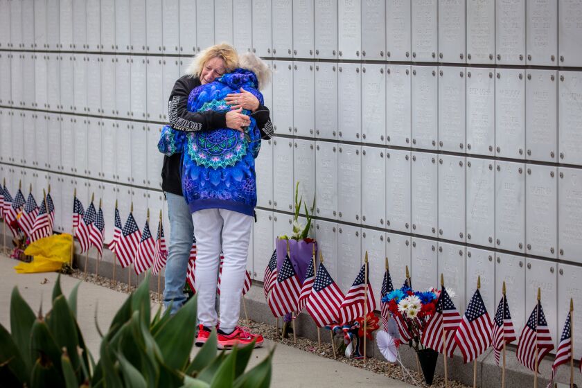 Los Angeles, CA - May 29: Meryle Moroney, left, hugs her mother Ruth, as they visit the remains of her father Carl, who died in November 2022, on Memorial Day ceremony at the Los Angeles National Cemetery, in Los Angeles, CA, Monday, May 29, 2023. The Moroney's were married for more than 65 years. (Jay L. Clendenin / Los Angeles Times)