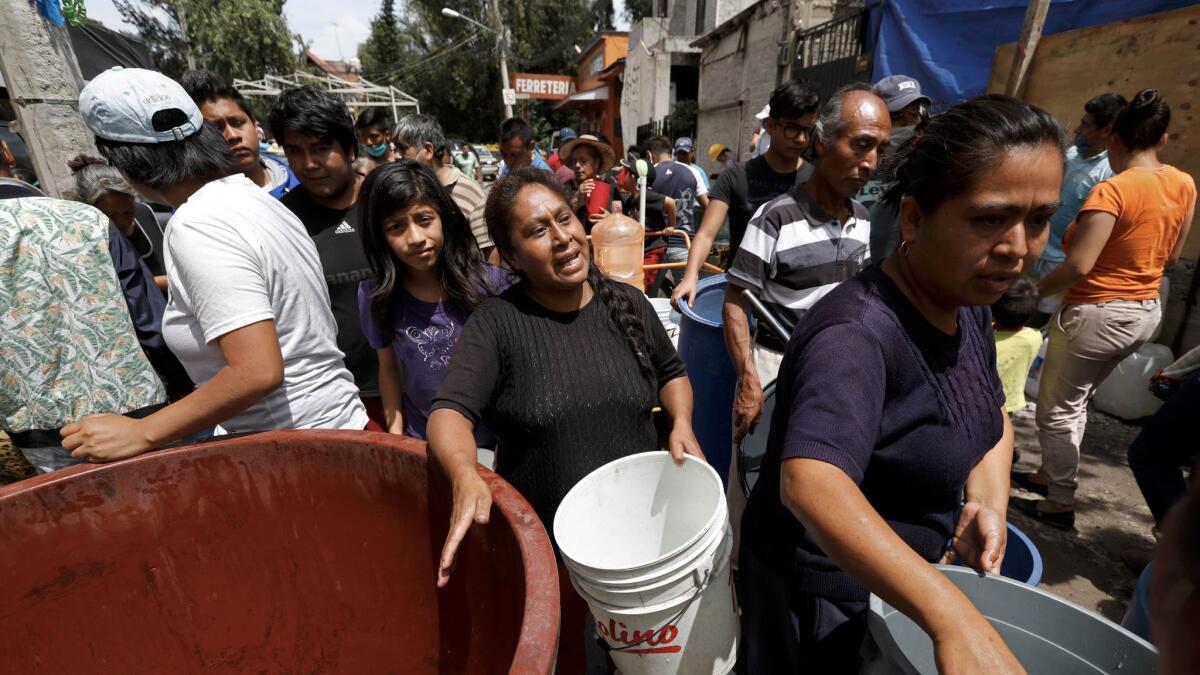 A woman asks for more water as people wait in line at a distribution area in Xochimilco.