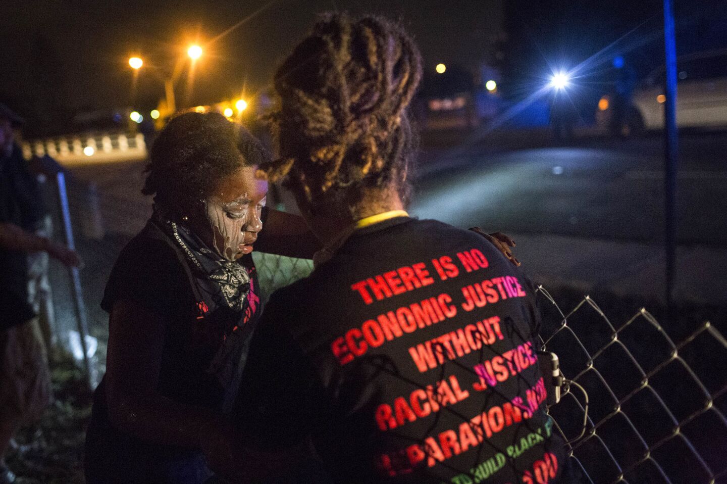 A protester uses milk to wash tear gas from her eyes after police used the gas to clear demonstrators who were blocking Interstate 277 in Charlotte, N.C., on Thursday.