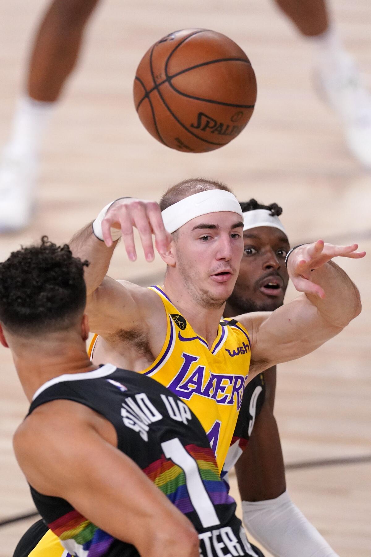 Lakers guard Alex Caruso elevates to make a pass over Nuggets forward Michael Porter Jr. during Game 4.