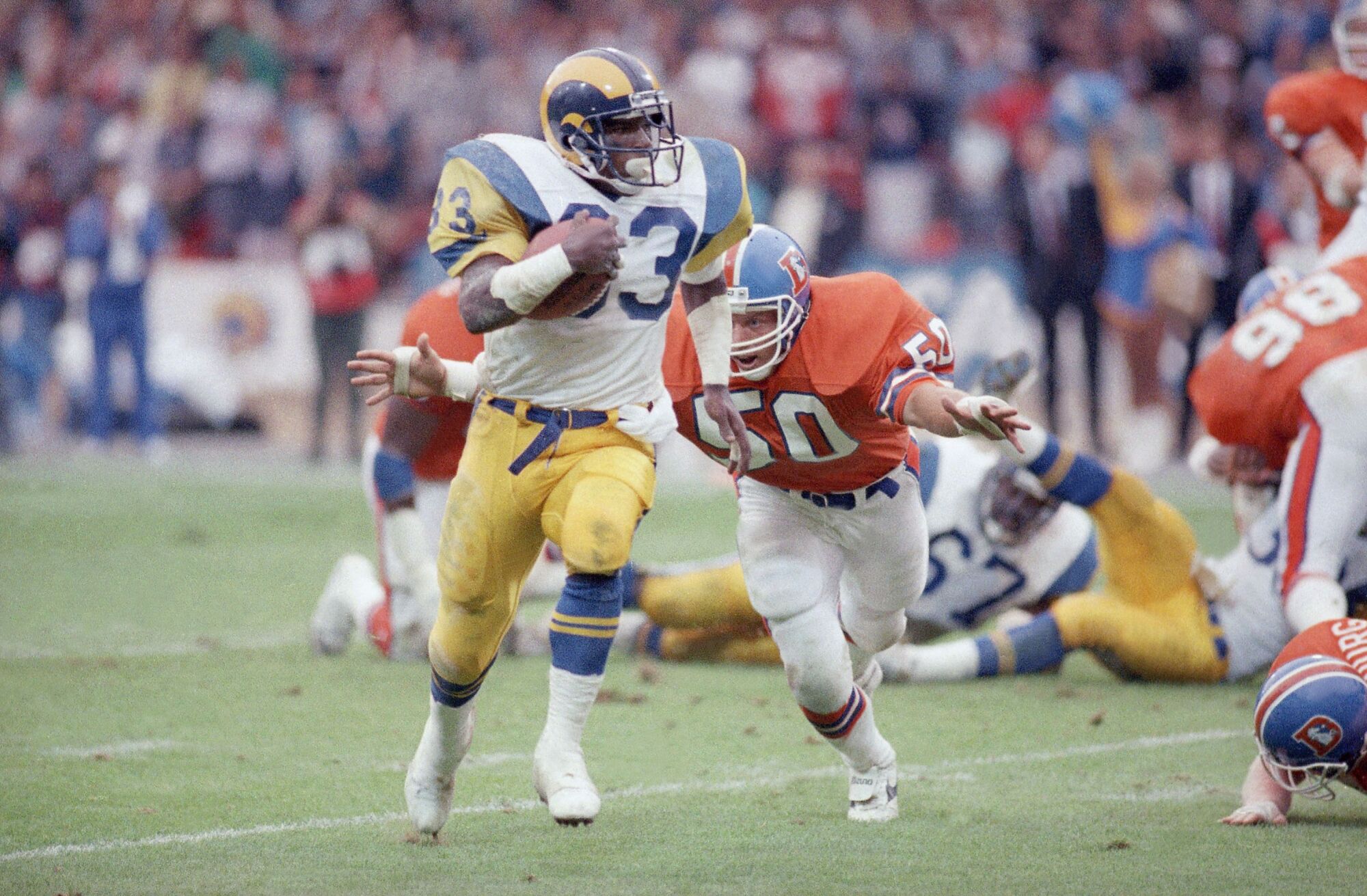 Rams running back Charles White runs with the ball against the Denver Broncos on Aug. 9, 1987.