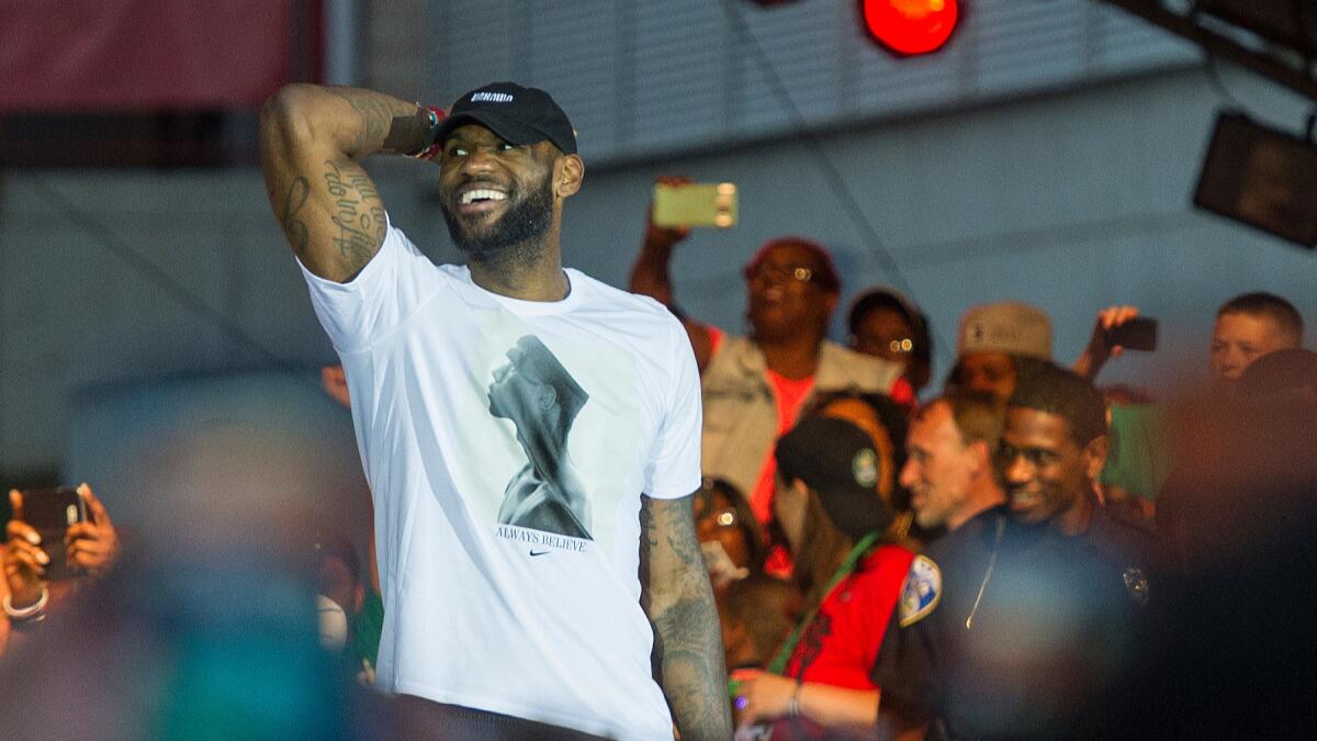 LeBron James celebrates the Cavaliers' NBA title with fans in Cleveland.