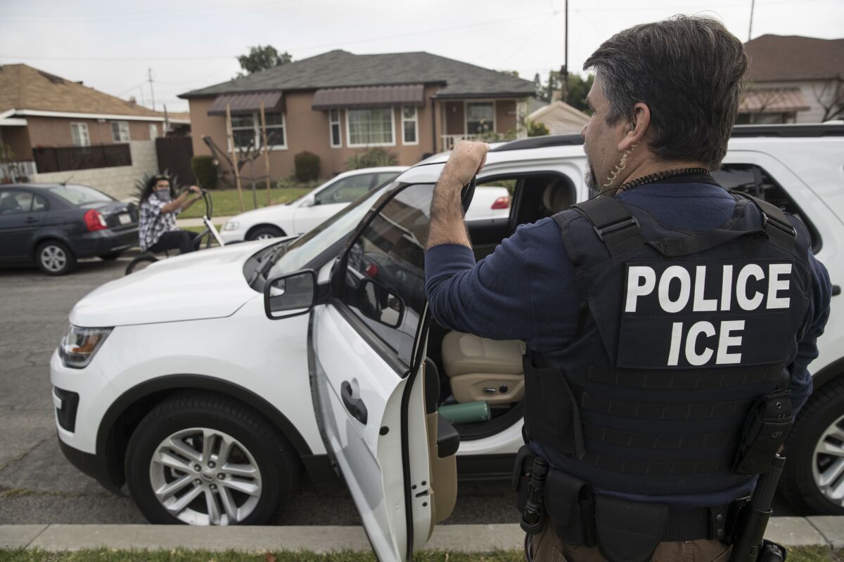 An ICE officer stands outside the home of a 47-year-old Mexican national in Montebello on April 18, 2017.
