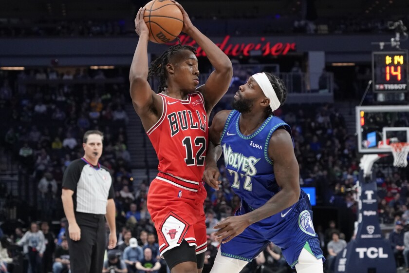 Chicago Bulls guard Ayo Dosunmu (12) tries to get past Minnesota Timberwolves guard Patrick Beverley (22) during the first half of an NBA basketball game Sunday, April 10, 2022, in Minneapolis. (AP Photo/Craig Lassig)