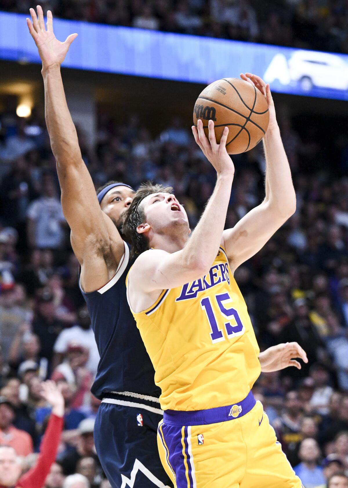 Lakers guard Austin Reaves beats Nuggets forward Bruce Brown to the basket for a layup.