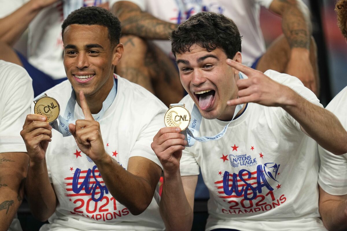 Tyler Adams, left, and Gio Reyna celebrate with their gold medals in the CONCACAF Nations League last year.