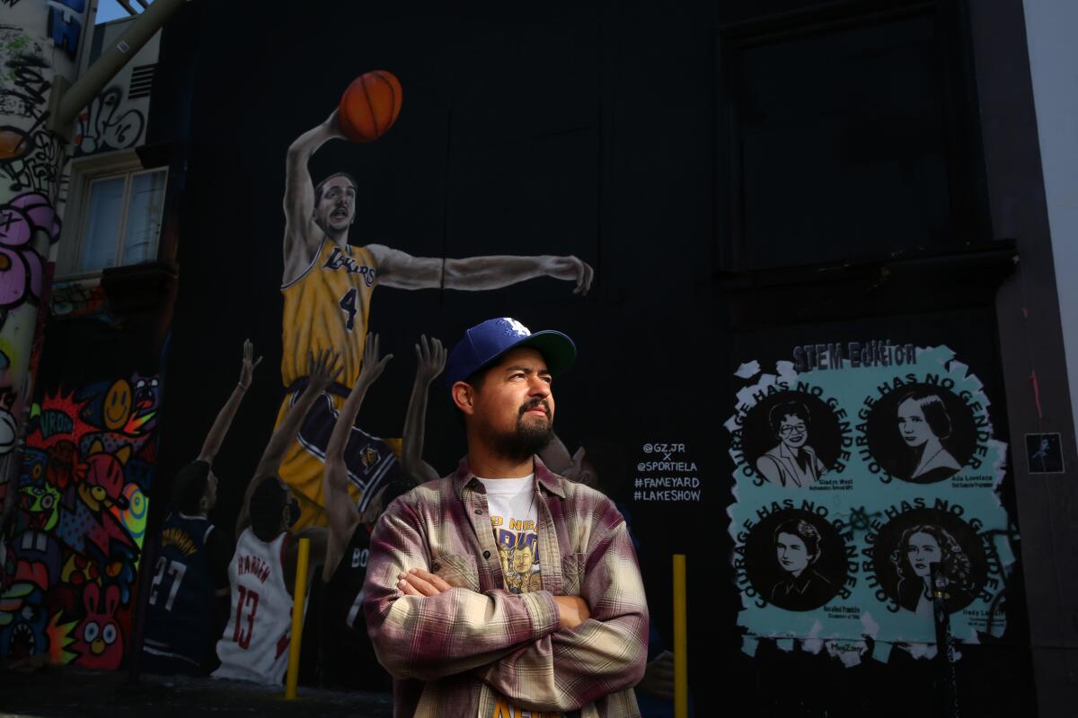 Artist Gustavo Zermeo Jr. stands in front of a mural he painted of Lakers guard Alex Caruso on Nov. 22. 