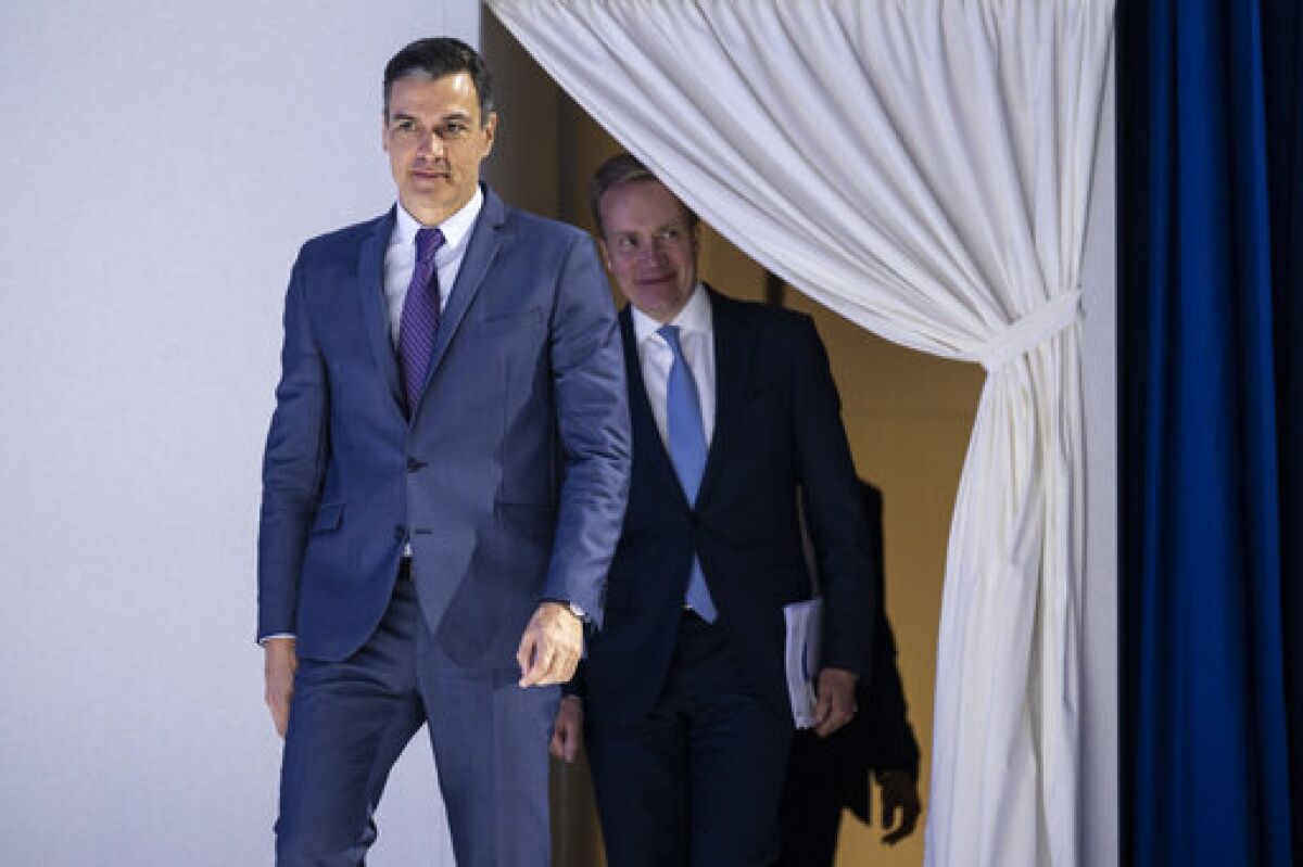 Pedro Sanchez, Prime Minister of Spain, left, arrives ahead of Borge Brende, President, World Economic Forum at the 51st annual meeting of the World Economic Forum, WEF, in Davos, Switzerland, Tuesday, May 24, 2022. The forum has been postponed due to the Covid-19 outbreak and was rescheduled to early summer. The meeting brings together entrepreneurs, scientists, corporate and political leaders in Davos under the topic "History at a Turning Point: Government Policies and Business Strategies" from 22 - 26 May 2022. (Gian Ehrenzeller/Keystone via AP)