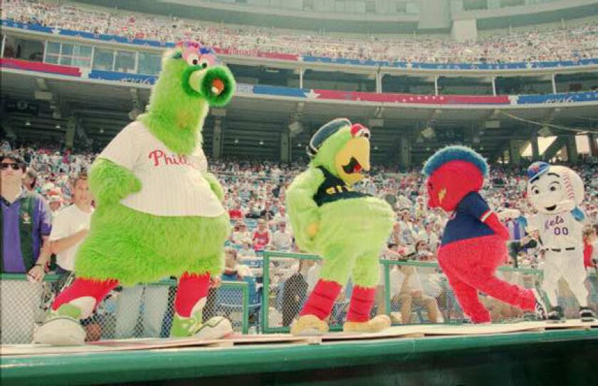 Baseball mascots, from left, The Phillie Phanatic, the Pirate Parrot, Homer the Brave and Mr. Met dance on a dugout at Veterans Stadium in Philadelphia during batting practice for the 1996 All-Star Game.