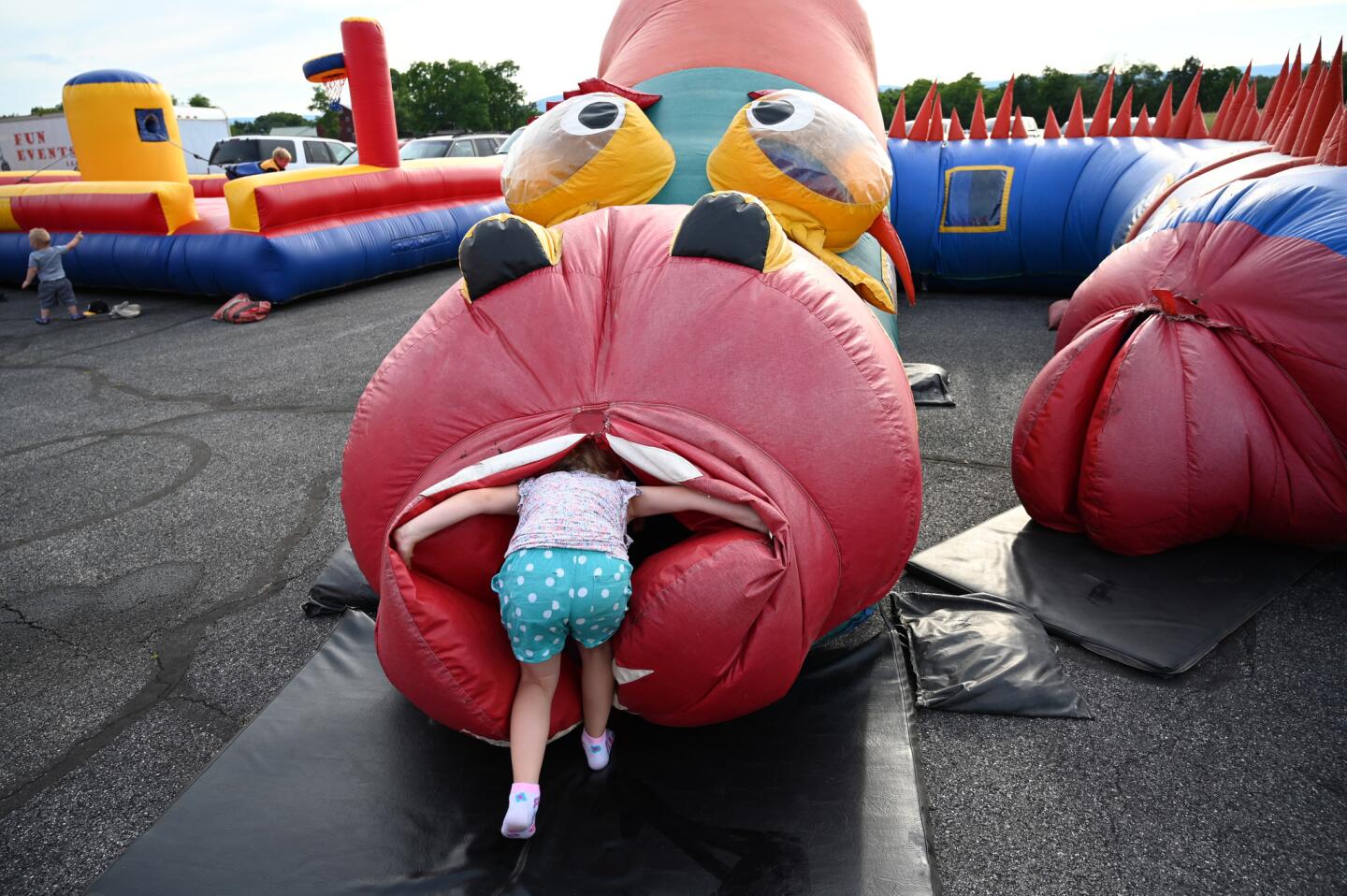 A child leaps head first into an inflatable tunnel during the carnival at the Harney Volunteer Fire Company on Tuesday, June 25.