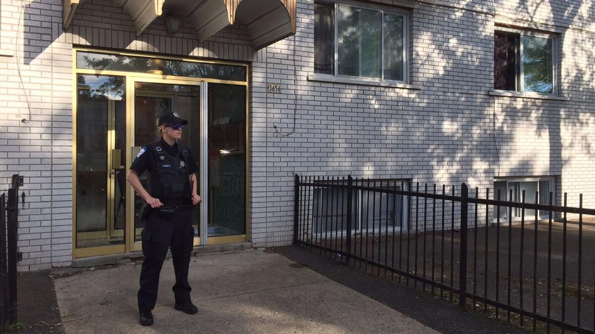 Police guard the front of the building in Montreal where Amor Ftouhi, who is suspected of stabbing a Michigan airport police officer, lived before traveling from Canada to the U.S. this month.