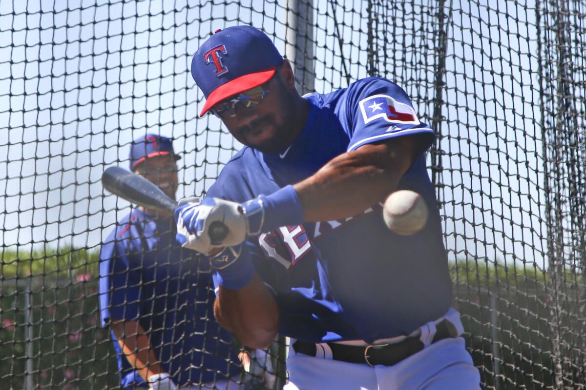 Seattle Seahawks quarterback Russell Wilson hits in the batting tent before a Texas Rangers spring training game against the San Diego Padres on March 28.