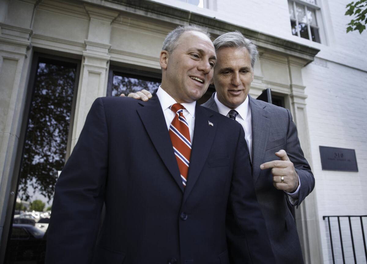 Majority Leader-elect Rep. Kevin McCarthy, R-Calif., right, talks with Rep. Steve Scalise, R-La., left, the newly elected House GOP whip, as they leave the Republican National Committee headquarters on Capitol Hill in Washington.