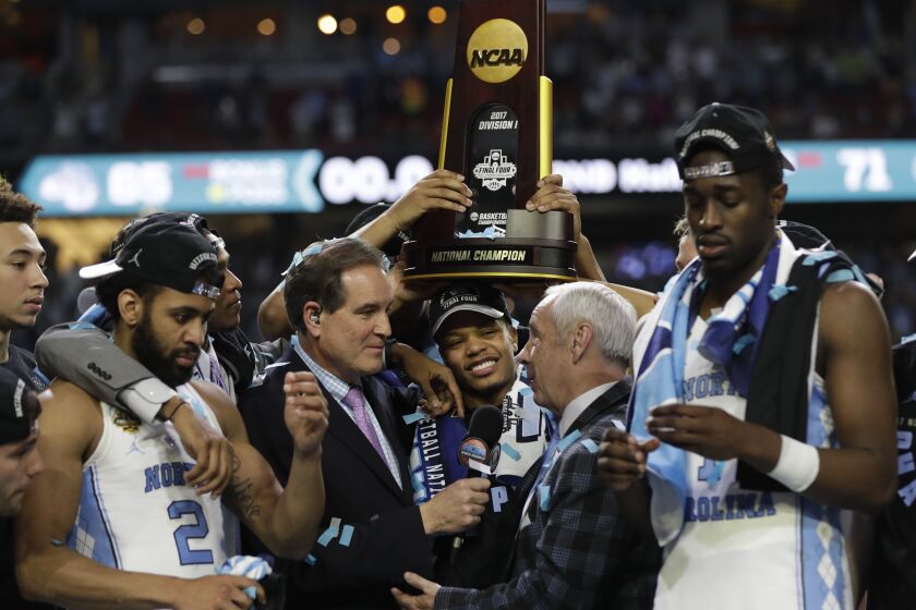 North Carolina head coach Roy Williams us interviewed as he celebrates with his team.