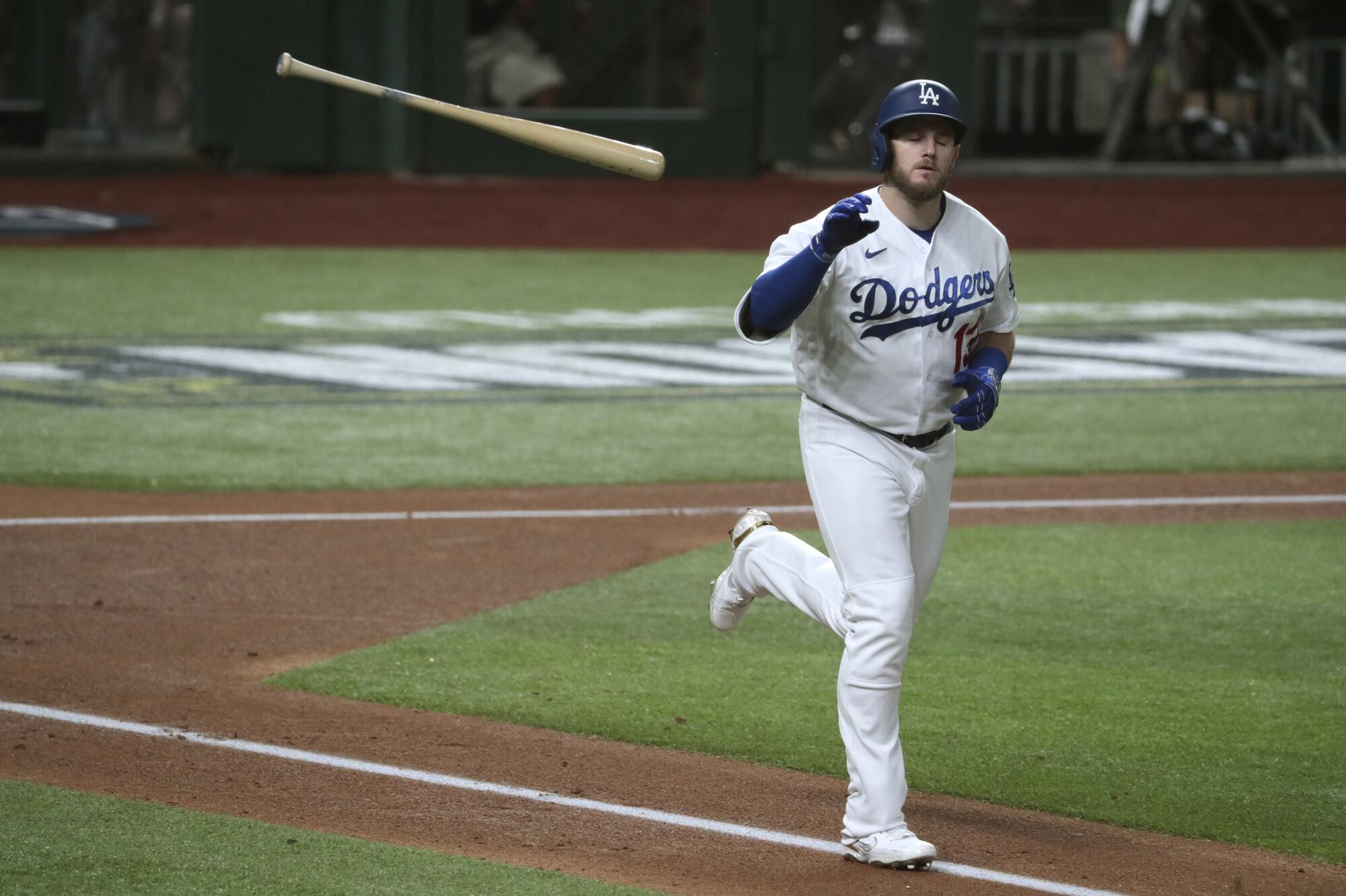 Dodgers first baseman Max Muncy flips away the bat after drawing a walk in the first inning of Game 1 of the NLCS.