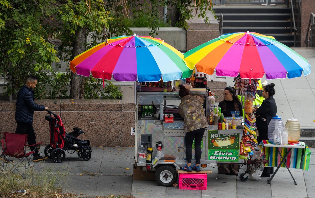A street food vendor with a broad, colorful umbrella in downtown L.A.