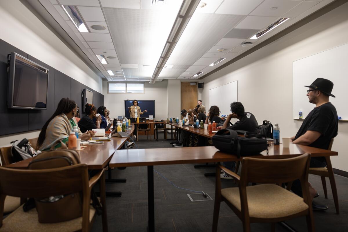 People sit in a classroom while listening to an instructor.