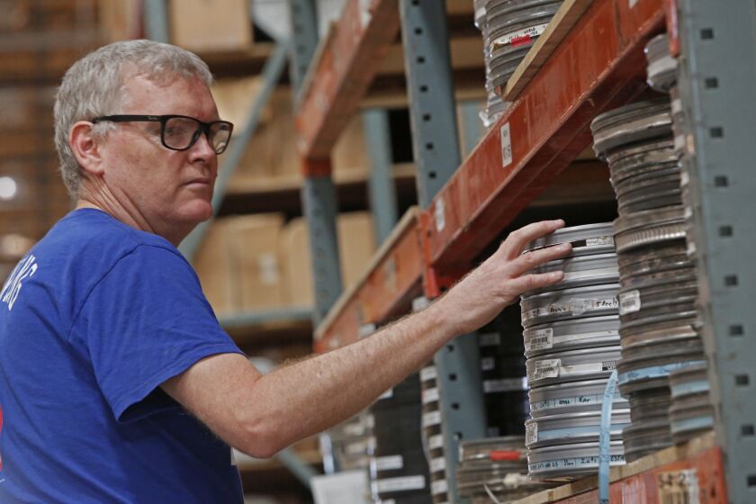 Ed Carter from the Academy of Motion Picture Arts and Sciences sorts through old film prints from Deluxe Film in a warehouse in Lebec. Once sorted they will be sent to the Academy in Hollywood. (Anne Cusack/Los Angeles Times)